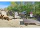 Back patio with two wooden chairs, grill, and lounge chair surrounded by trees and fence at 205 E Skyline Vw, Dallas, GA 30157