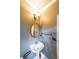 Elegant powder room featuring a pedestal sink, decorative mirror, and designer lighting at 2659 Lakefield Sw Pass, Marietta, GA 30064