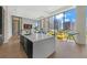 Open-concept living area with a modern kitchen island and city views through large windows at 40 12Th Ne St # 903, Atlanta, GA 30309