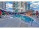 A beautiful outdoor pool with lounge chairs and umbrellas in a modern building complex under a partly cloudy sky at 40 12Th Ne St # 903, Atlanta, GA 30309
