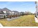 Spacious backyard featuring a black fence, lush green grass, and landscaped planter beds with young rose bushes at 501 Blackberry Ln, Canton, GA 30115