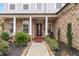 Charming front porch with brick columns, dark front door, swing and manicured landscaping at 501 Blackberry Ln, Canton, GA 30115