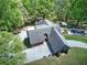Aerial view of a house with a large backyard and a long driveway surrounded by lush trees at 5894 Highway 20 Ne, Cartersville, GA 30121