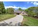Exterior view of a brick home with a long driveway, covered parking, and surrounded by lush greenery at 5894 Highway 20 Ne, Cartersville, GA 30121