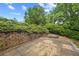 Stone back patio surrounded by lush greenery offers a private outdoor space at 4505 Lakefield Bnd, Berkeley Lake, GA 30096