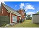 Cozy backyard featuring a small shed, green lawn, and the brick house at 4505 Lakefield Bnd, Berkeley Lake, GA 30096