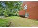 A well-maintained backyard with a view of the brick house exterior at 4505 Lakefield Bnd, Berkeley Lake, GA 30096