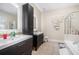 Sleek bathroom featuring double vanities, modern fixtures, and a separate shower and tub at 4505 Lakefield Bnd, Berkeley Lake, GA 30096