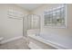Bright bathroom featuring a soaking tub, tiled floor, and glass shower at 4505 Lakefield Bnd, Berkeley Lake, GA 30096