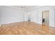 Bright bedroom with hardwood floors, white trim, and view of a bathroom at 4505 Lakefield Bnd, Berkeley Lake, GA 30096