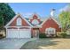 Charming two-story brick home with a well-manicured lawn and a two-car garage at 4505 Lakefield Bnd, Berkeley Lake, GA 30096