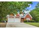 A two-story brick home with an attached two-car garage and front lawn at 4505 Lakefield Bnd, Berkeley Lake, GA 30096