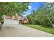 A two-story brick home with an attached two-car garage and a long driveway at 4505 Lakefield Bnd, Berkeley Lake, GA 30096