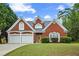 Charming brick home with a two-car garage and a well-manicured front lawn under a partly cloudy sky at 4505 Lakefield Bnd, Berkeley Lake, GA 30096