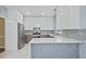Contemporary kitchen with two-tone cabinets, stainless steel appliances, and a marble waterfall island at 4505 Lakefield Bnd, Berkeley Lake, GA 30096
