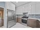 Contemporary kitchen with two-tone cabinets, stainless steel appliances, and marble countertops at 4505 Lakefield Bnd, Berkeley Lake, GA 30096