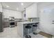 Modern kitchen with white cabinets, stainless steel appliances, and a marble island at 4505 Lakefield Bnd, Berkeley Lake, GA 30096