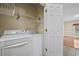 Efficient laundry room with washer, dryer, shelving, and access to the living area at 4505 Lakefield Bnd, Berkeley Lake, GA 30096