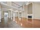 Open living room featuring hardwood floors, fireplace, pillars, and a ceiling fan at 4505 Lakefield Bnd, Berkeley Lake, GA 30096