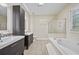 Bright primary bath featuring double sink vanity, soaking tub and glass shower at 4505 Lakefield Bnd, Berkeley Lake, GA 30096