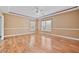 Spacious main bedroom with hardwood floors, tray ceiling, and natural light from large windows at 4505 Lakefield Bnd, Berkeley Lake, GA 30096
