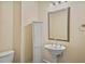 Traditional powder room featuring a pedestal sink, accent mirror, and painted white storage cabinet at 4505 Lakefield Bnd, Berkeley Lake, GA 30096