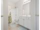 Well-lit bathroom with vanity, tile floor, and shower with floral curtain at 4573 Caleb Xing # 20, Powder Springs, GA 30127