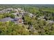 Aerial view of houses surrounded by trees and a street with parked cars nearby at 313 Ellenwood Dr, Bowdon, GA 30108
