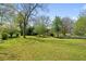 A beautiful backyard with lush green grass, mature trees, and landscaping creates a serene outdoor space at 313 Ellenwood Dr, Bowdon, GA 30108