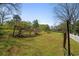 Expansive backyard featuring lush green grass, scattered trees, and a partially fenced perimeter, ideal for outdoor activities at 313 Ellenwood Dr, Bowdon, GA 30108