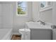 Bright bathroom with a white vanity, sink, toilet, and shower-tub combination at 313 Ellenwood Dr, Bowdon, GA 30108