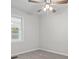 Bright, carpeted bedroom features a ceiling fan and view to the neighborhood at 313 Ellenwood Dr, Bowdon, GA 30108