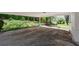View from the carport showing a lush and landscaped backyard with blooming azaleas at 313 Ellenwood Dr, Bowdon, GA 30108