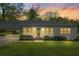 Inviting home with a well-lit front facade, manicured lawn, and attached carport at 313 Ellenwood Dr, Bowdon, GA 30108