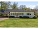Inviting home boasts green lawn, side carport, and a bright white exterior at 313 Ellenwood Dr, Bowdon, GA 30108