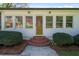 Close up of the charming exterior featuring a decorative glass front door and manicured landscaping at 313 Ellenwood Dr, Bowdon, GA 30108