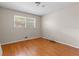 Simple bedroom featuring hardwood floors, neutral walls, and natural light from a window at 3944 Woburn Dr, Tucker, GA 30084