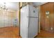 White refrigerator in kitchen with wooden floors and adjacent storage at 3944 Woburn Dr, Tucker, GA 30084