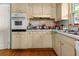 Classic kitchen design featuring wooden floors, cabinets, and a mosaic tile backsplash at 3944 Woburn Dr, Tucker, GA 30084
