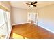 Well-lit living room with hardwood floors, ceiling fan, and french doors at 505 Tilbury Dr, Suwanee, GA 30024