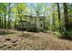 View of backyard showcasing a deck that overlooks a scenic wooded lot with lush greenery and mature trees at 7771 A C Smith Rd, Cumming, GA 30028