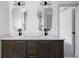 A bathroom with dual sinks, modern mirrors and lighting, and a door leading to the shower at 7771 A C Smith Rd, Cumming, GA 30028