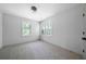 Bright bedroom with two windows, carpeted floor, neutral walls and ceiling fan light, creating a comfortable atmosphere at 7771 A C Smith Rd, Cumming, GA 30028