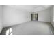 A spacious bedroom with carpet, white walls, and doors leading to the other rooms at 7771 A C Smith Rd, Cumming, GA 30028