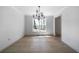 A dining room with white walls, hardwood flooring, and a modern light fixture under a window at 7771 A C Smith Rd, Cumming, GA 30028