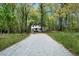View down long driveway to a charming two-story home surrounded by mature trees at 7771 A C Smith Rd, Cumming, GA 30028