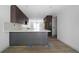 An open kitchen features gray cabinets, white countertops and backsplash, and hardwood floors at 7771 A C Smith Rd, Cumming, GA 30028