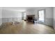 A spacious living room with hardwood floors and a brick fireplace beneath a large window at 7771 A C Smith Rd, Cumming, GA 30028