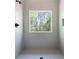 A tiled walk-in shower features a glass window, a rainfall shower head, and a built-in niche at 7771 A C Smith Rd, Cumming, GA 30028