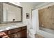 This bathroom features a granite countertop, framed mirror, and tiled shower and tub combo at 2808 Broughton Se Ln, Atlanta, GA 30339